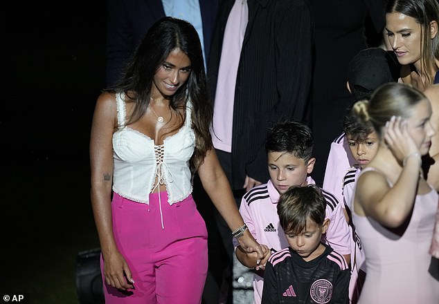 The model led their sons, Thiago, Matteo and Ciro, across the platform after being presented