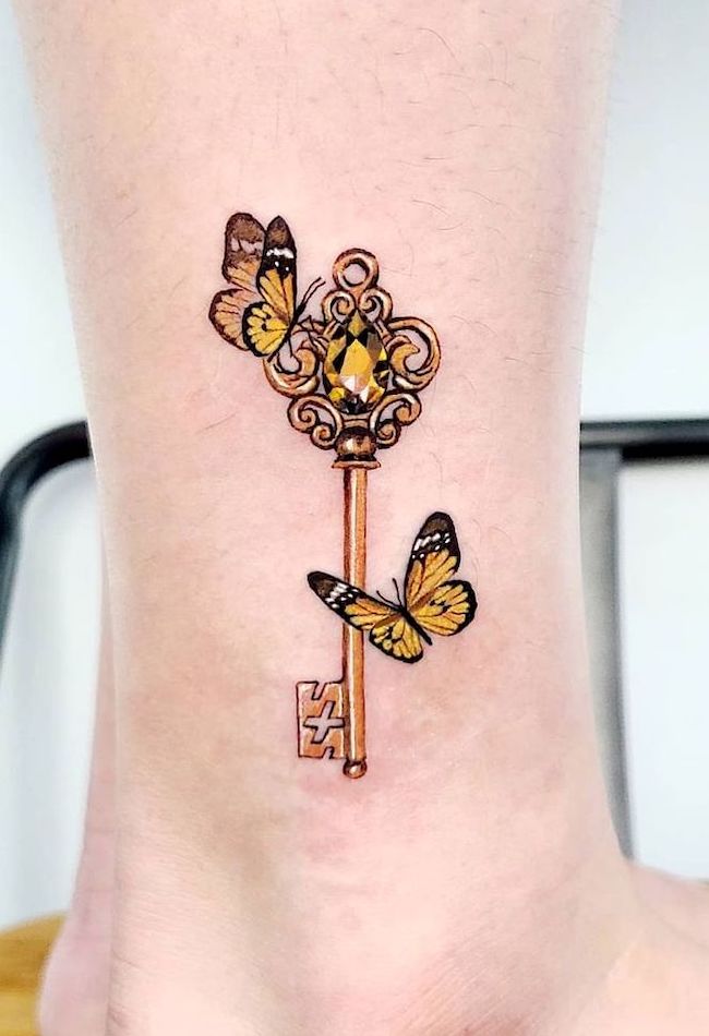Golden key butterfly ankle tattoo by @tattooist_violet