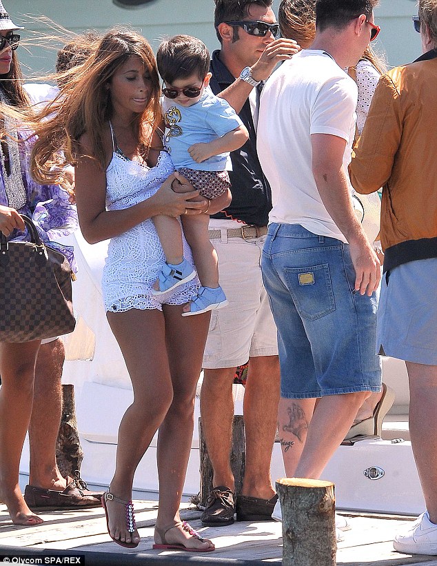 Hot mama: Antonella lends her son a pair of sunglasses as they prepare to soak up the sun