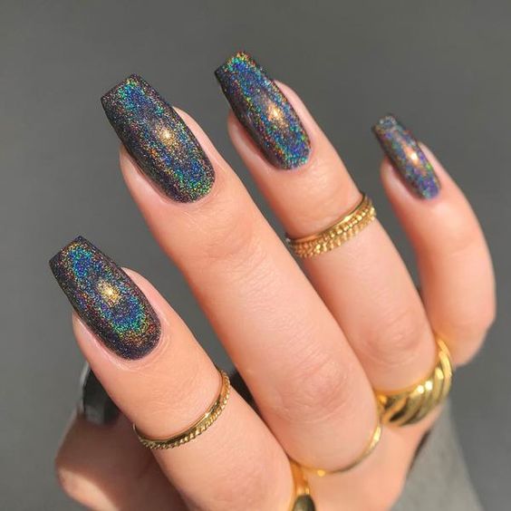 Sparkling galaxy-themed black nail polish on long coffin nails