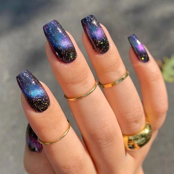 Black nail color with galaxy-inspired nail art on medium tapered square nails