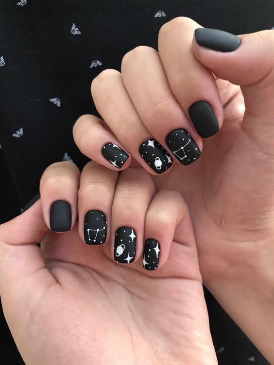 Black nail color in matte finish with galaxy nail arts on short tapered square nails