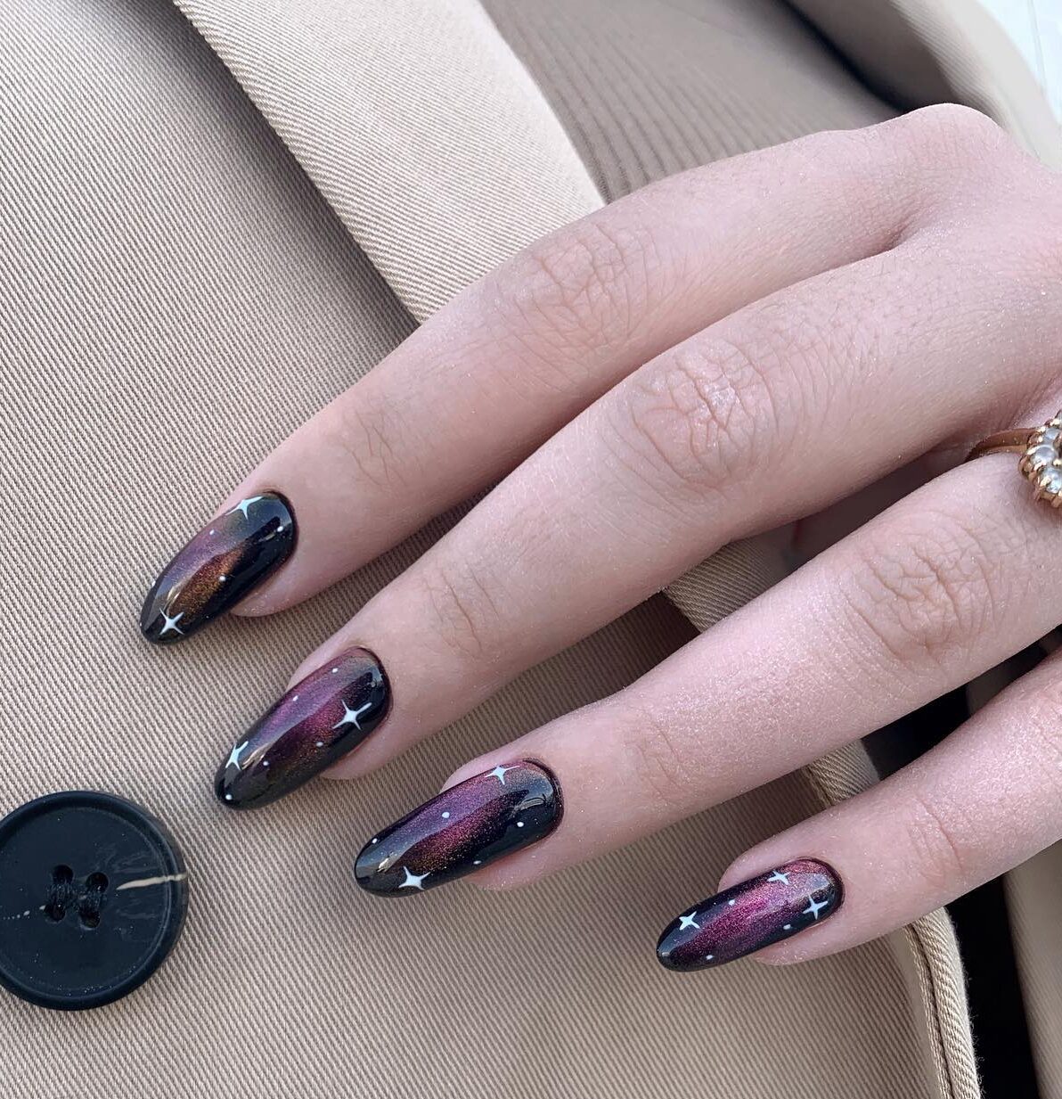 Combination of black and purple nail colors with galaxy-inspired nail design on long round nails