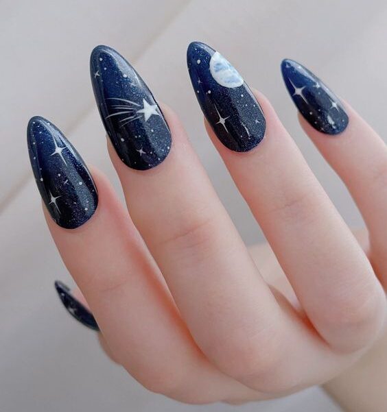 Dark blue nail color with galaxy-themed nail art on long almond nails
