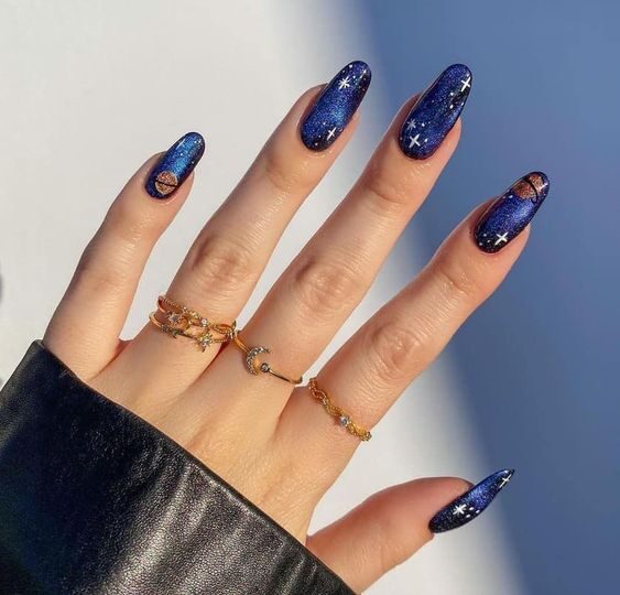Blue nail color with galaxy-themed nail design on long round nails