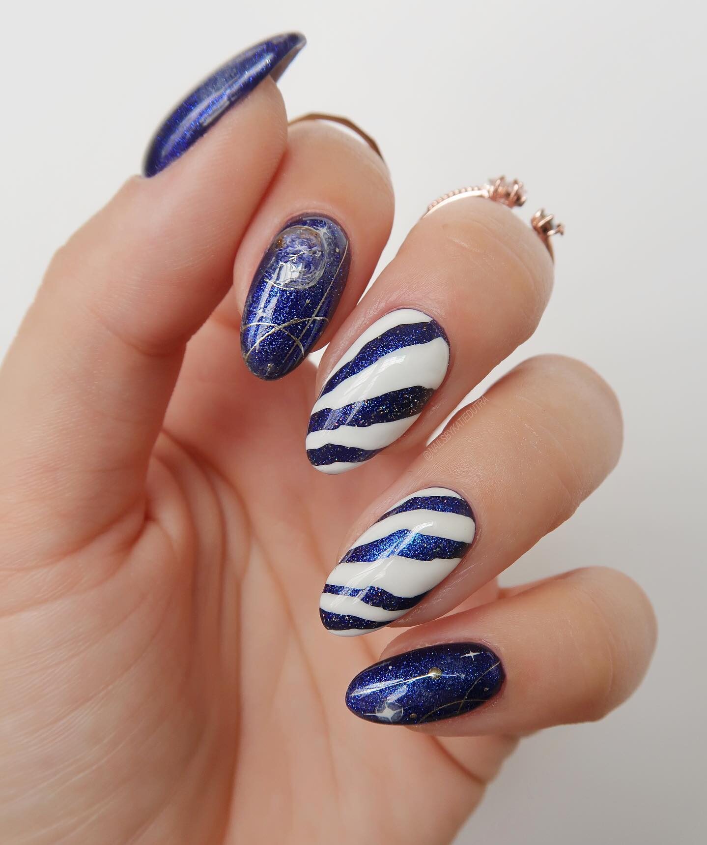 Blue and white nail colors with galaxy-themed nail art on medium round nails