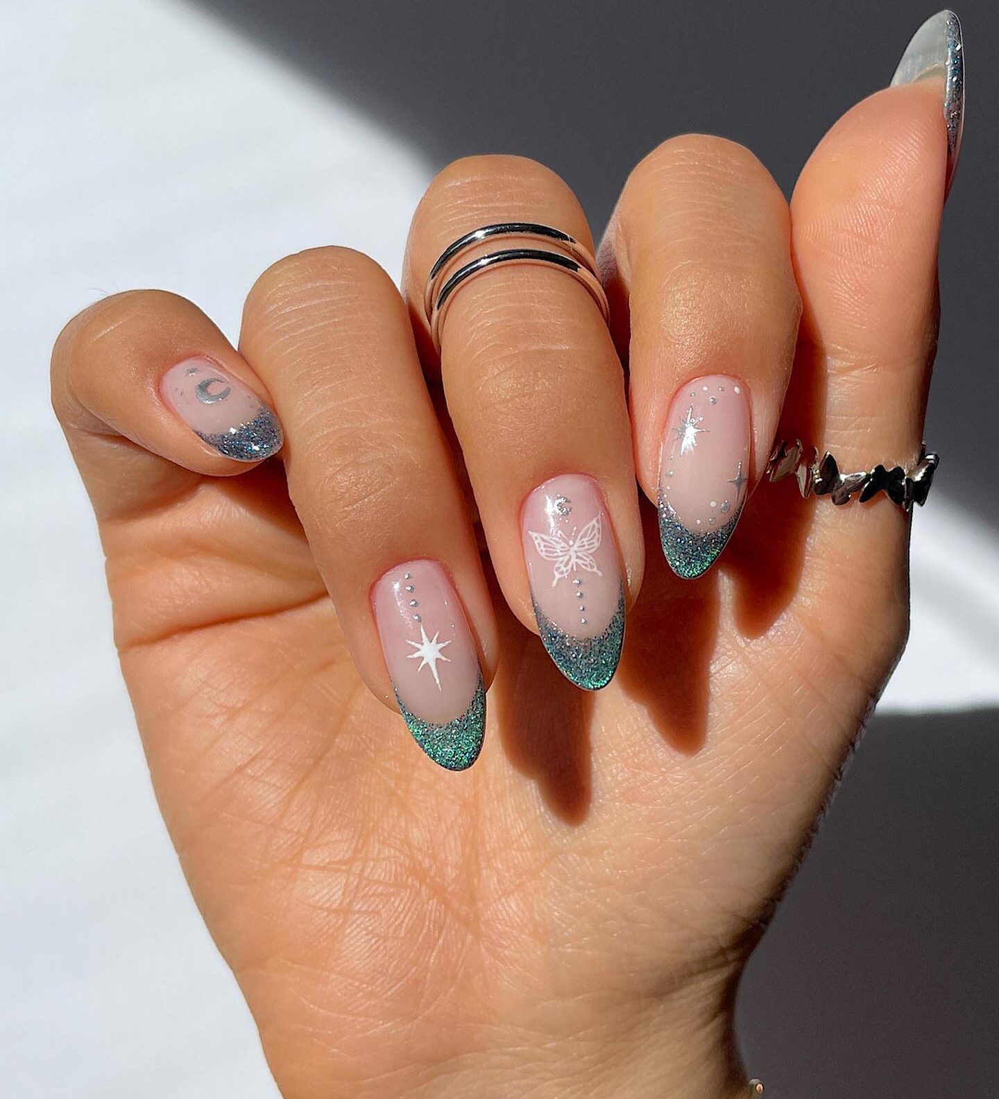 Chrome light blue French tips and celestial elements nail arts on long round nails