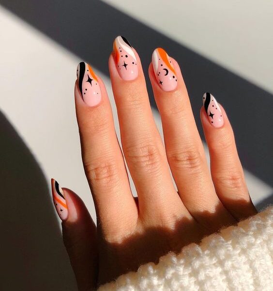 Black, white, and orange swirling patterns with celestial elements nail arts on medium round nails