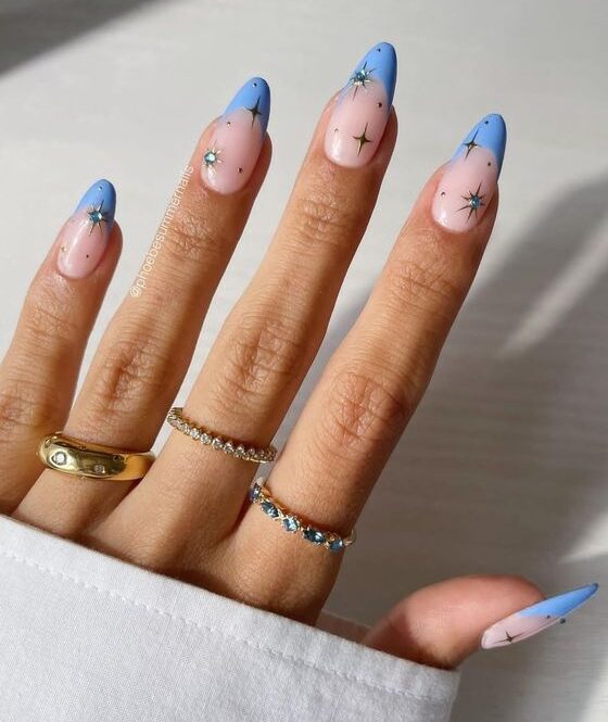 Light blue French tips with celestial elements nail designs on long almond nails