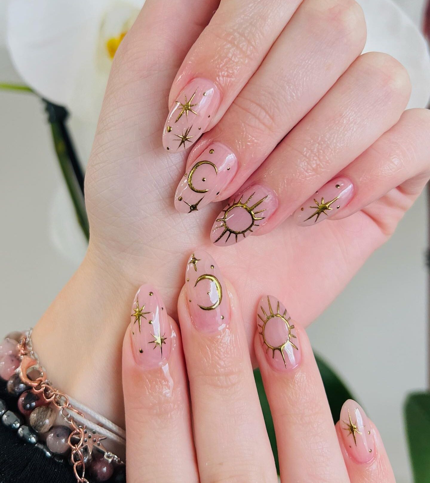 Clear long round nails with gold celestial elements nail designs