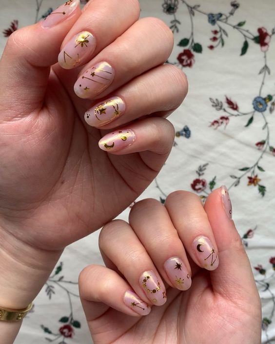 Clear short round nails with gold celestial elements nail designs