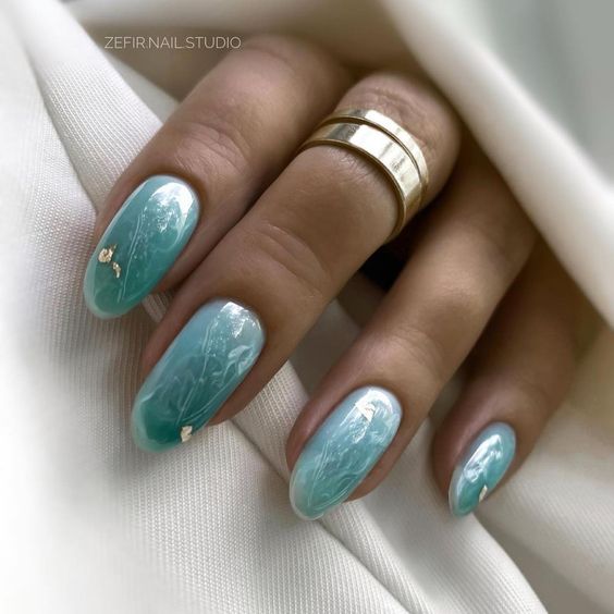 Light green galaxy-inspired nail art on medium round nails