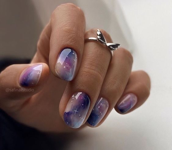 Purple marbled galaxy nail design on short round nails