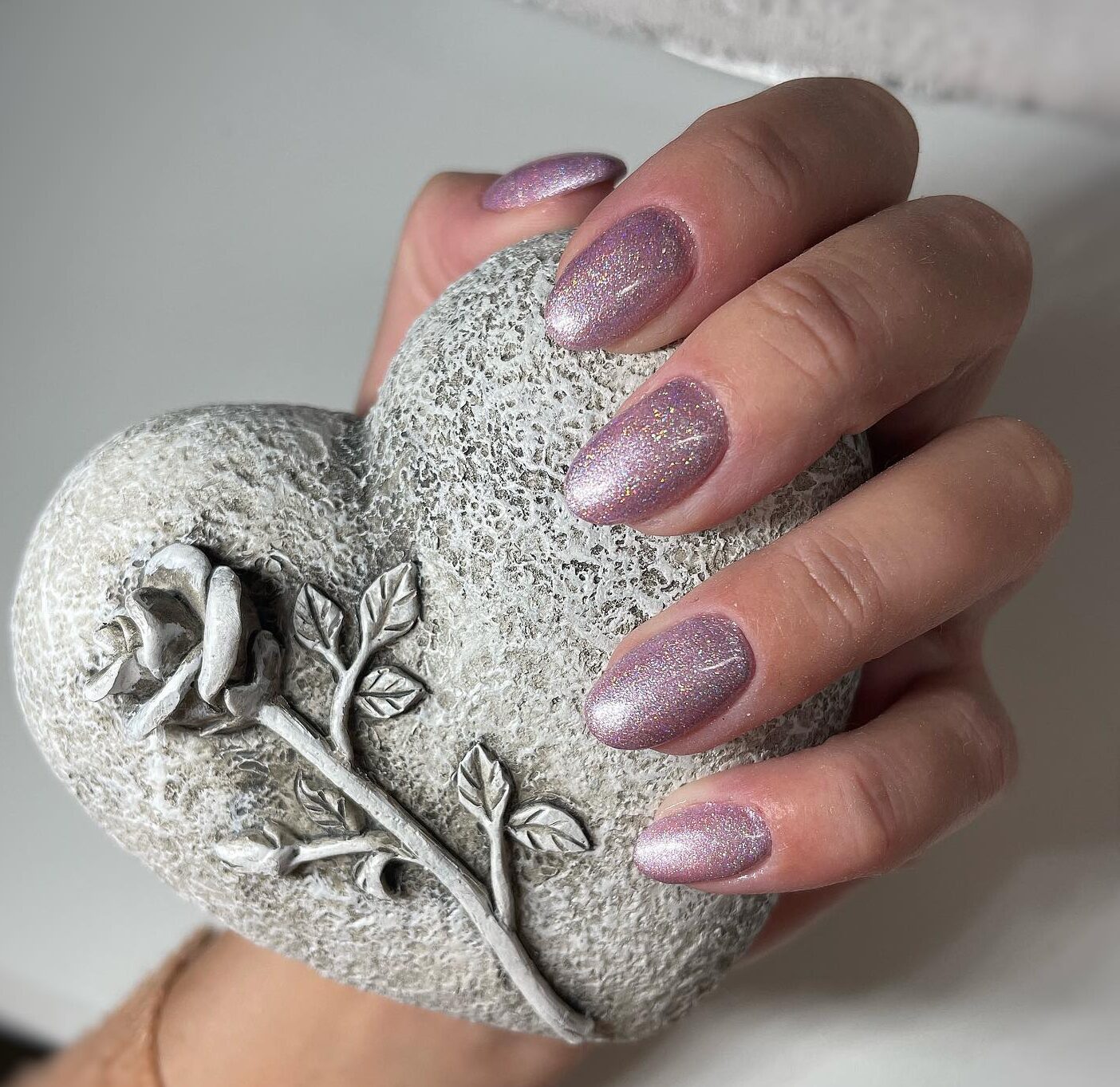 Light pink glittery nail polish on short round nails