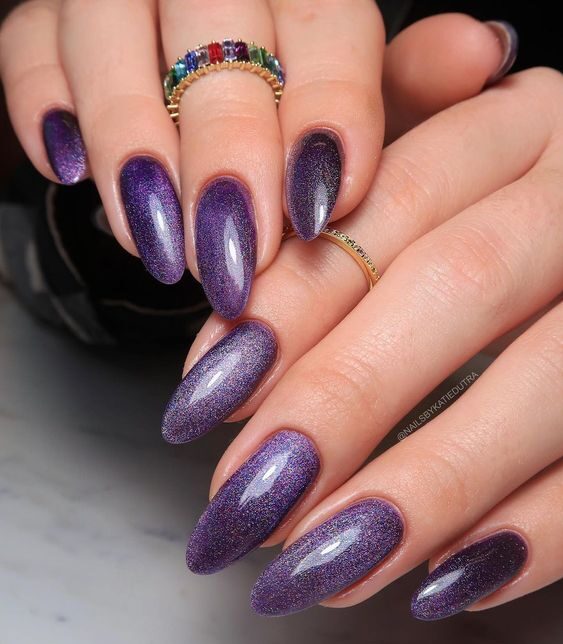 Shimmering galaxy-themed purple nail polish on long round nails