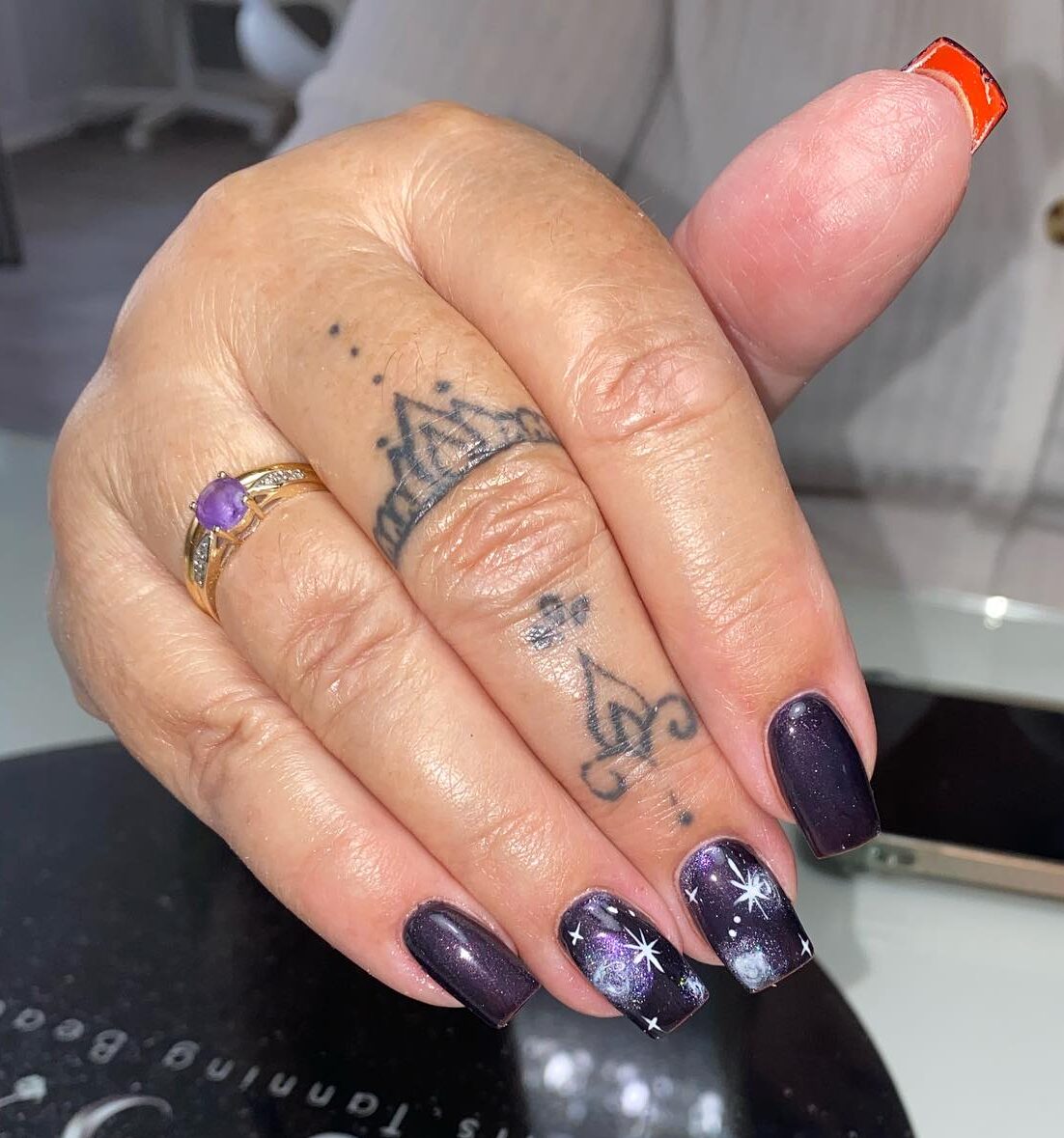 Deep purple nail color with galaxy nail art on medium square nails
