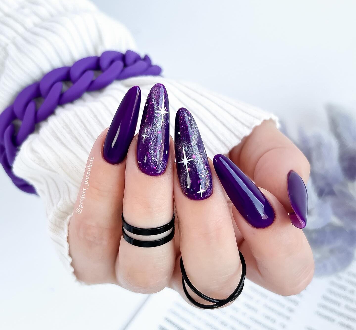 Deep purple nail polish with galaxy nail art on long almond nails