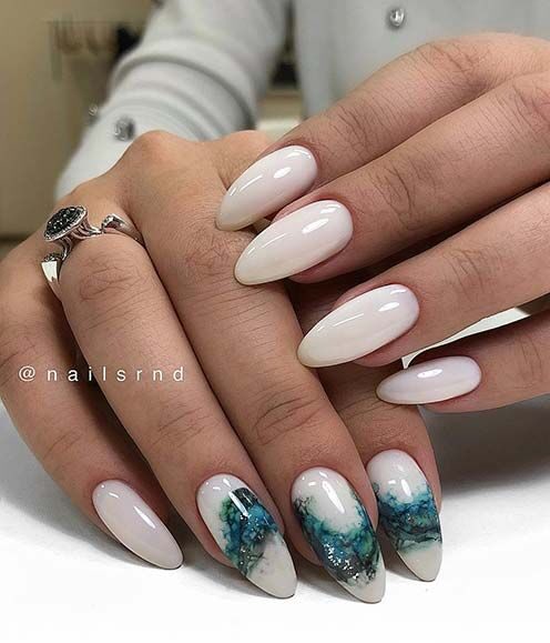 Polished white nail color with marbled galaxy nail design on long almond nails