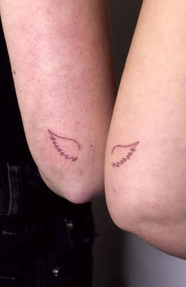 Matching wings elbow tattoo by @alunar.ink
