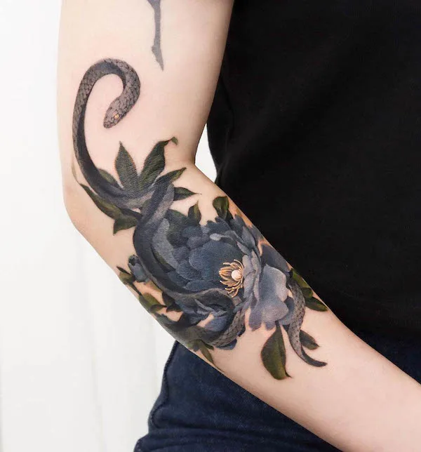 Snake and flowers elbow tattoo by @guppy.flowertattoo