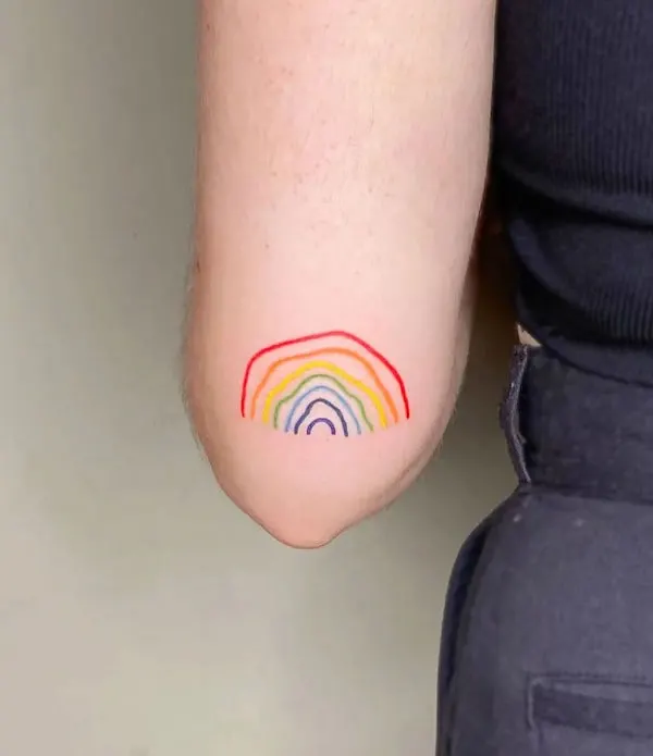 Hand drawn rainbow tattoo on elbow by @purensonmez.ink