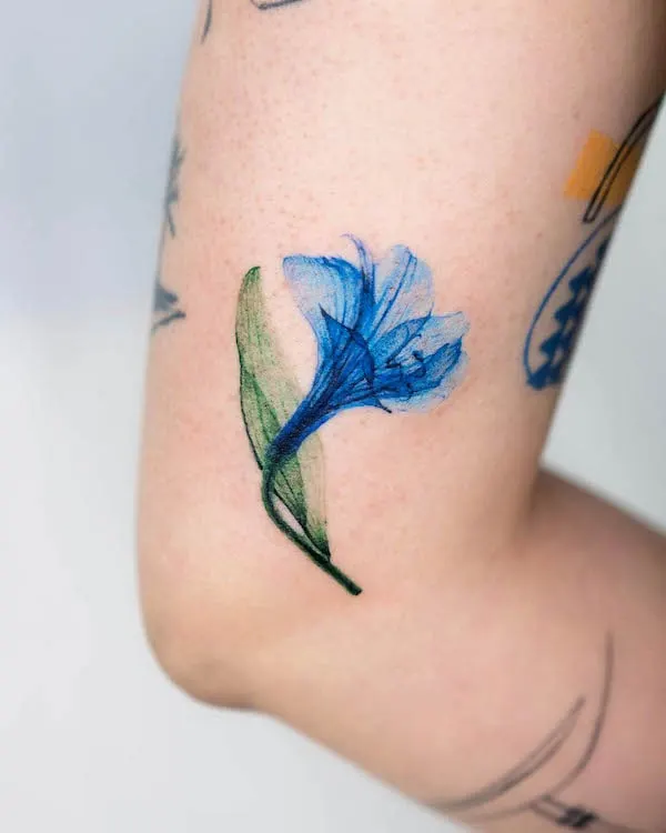 Blue lily elbow tattoo by @pokhy_tattoo