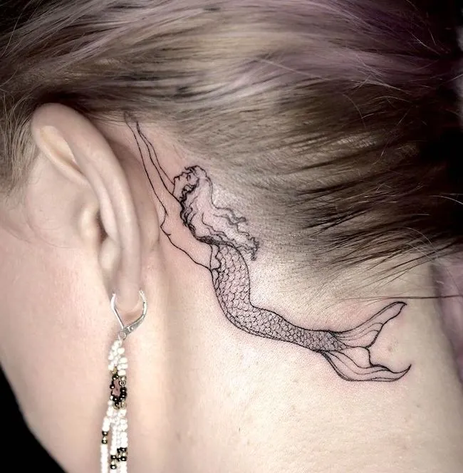 A mermaid tattoo behind the ear by @gelo.ink