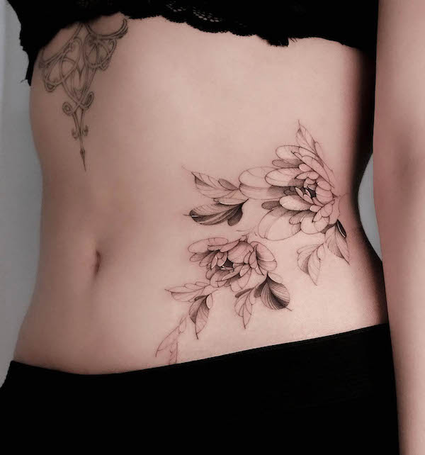 Black and grey flower waist tattoo by @saku.tatt_