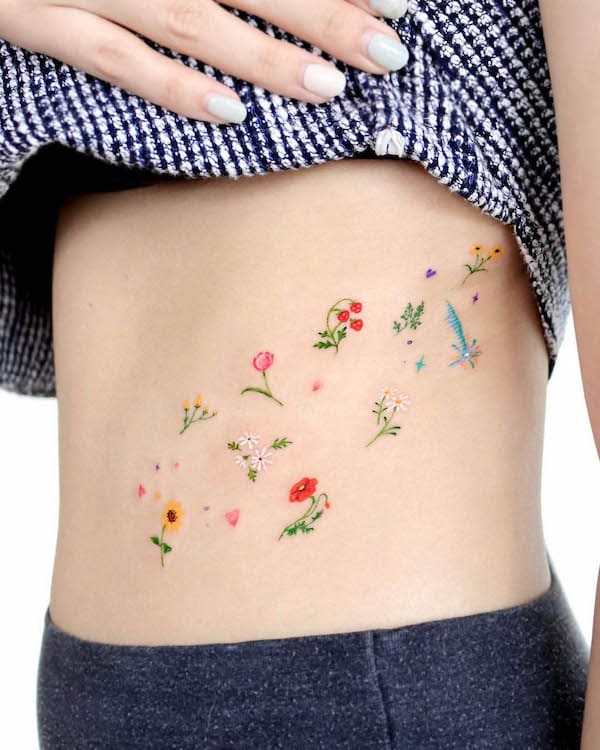 Small scattered flowers waist tattoo by @ovenlee.tattoo