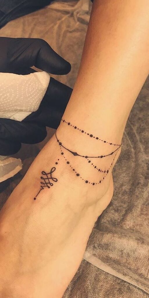 4 TOP 4 Tatuajes en el Tobillo Cadenita fina a modo de tobillera con varias vueltas y pendiente de unalome en el pie