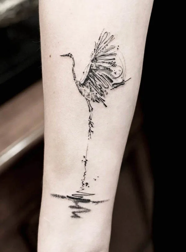 Crane standing on water tattoo by @joytattoo