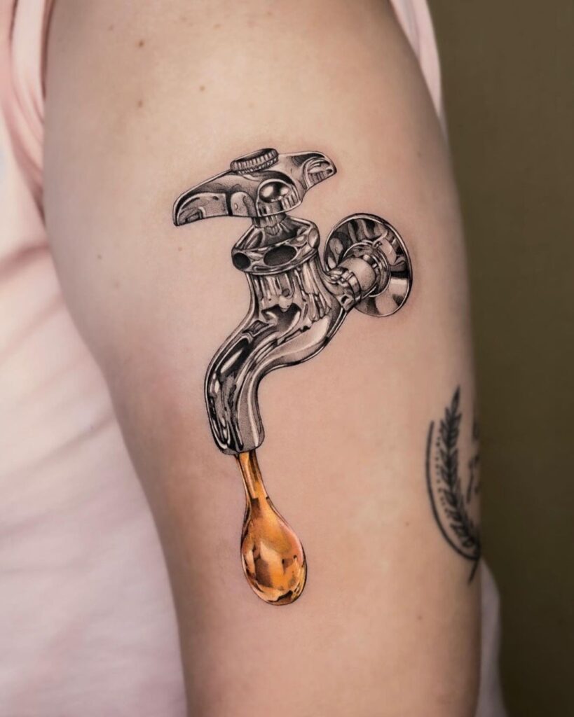 chrome tattoo of a shiny silver tap with gold water dripping out.