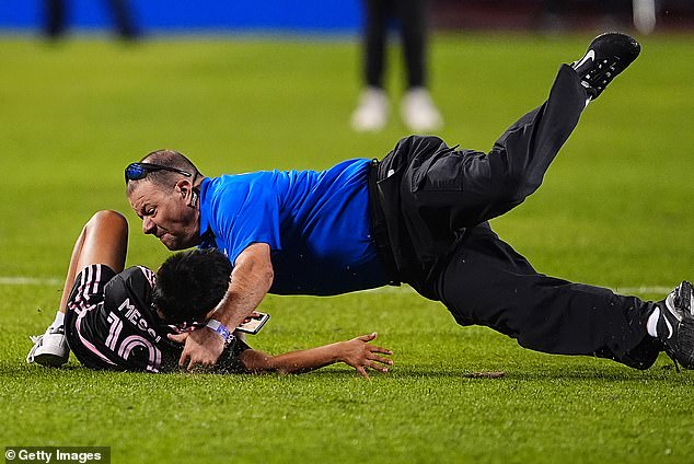 Another young fan - wearing a Messi jersey - was tackled by stadium security during the game