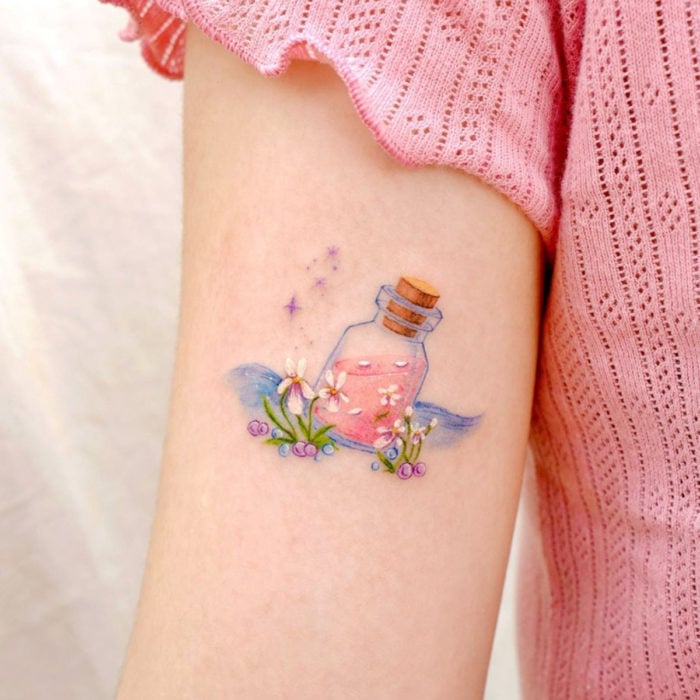 Mini, small tattoo of white feminine flowers with bottle with potion, on the arm