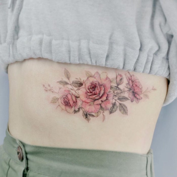 Mini, small tattoo of feminine rose flowers on the ribs