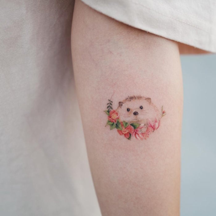 Mini, small tattoo of feminine rose flowers with hedgehog on the arm